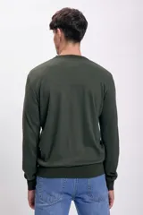 Sweater verde oscuro de punto con cuello redondo y mangas largas.