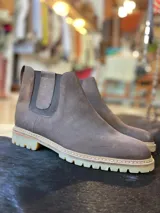 Botas chelsea de caña baja en color marrón, confeccionadas en cuero con elásticos laterales y suela dentada de goma.