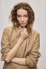 Blazer de silueta amplia y largo por debajo de la cadera, color café, confeccionado en tela suave y liviana. Presenta cuello con solapas, cierre cruzado con botones y bolsillos laterales con tapa.