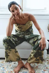 Pantalón de tiro medio confeccionado en mezcla de viscosa, con cintura elástica ajustable mediante cordón y diseño holgado. Presenta un estampado floral en tonos verde oscuro y beige, con detalle de panel contrastante en el bajo.