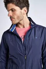 Campera liviana de nylon color gris oscuro, con cierre frontal completo, cuello subido y puños y cintura acanalados con rayas en rojo y blanco. Presenta logo bordado en el pecho y bolsillos laterales con cierre.