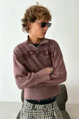 Su&eacute;ter de punto Nude Project, modelo Beast Quarter, color marr&oacute;n con efecto lavado y detalles desgastados en los pu&ntilde;os y la cintura. Cuenta con dise&ntilde;o half-zip, cuello polo y el logo de la marca estampado en el frente y las mangas.