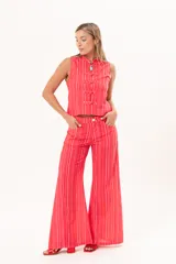 Pantalón de tiro medio y pierna amplia, con diseño a rayas en tonos rojos y rosados, bolsillos y pasacintos.