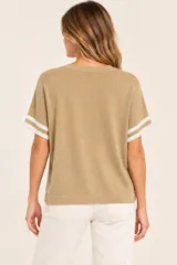 Remera tejida de punto color camel con cuello redondo y mangas cortas holgadas que presentan franjas blancas en los puños.