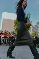 Falda midi tubo jaspeada en color gris oscuro, de tiro alto, con abertura en la espalda y cierre trasero con cremallera oculta.