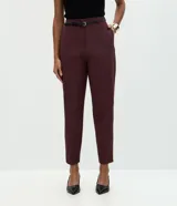 Pantalón carrot sastrero de corte recto y cintura alta, confeccionado en crepé. Presenta trabillas en la cintura, cierre tradicional y bolsillos traseros decorativos. Incluye un cinturón fino de material sintético.