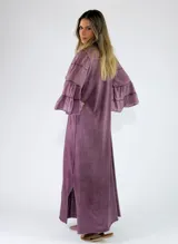 Vestido largo negro de corte holgado, con escote en V y mangas largas con volados en los puños.