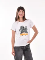 Remera blanca de manga corta con cuello redondo y un estampado frontal que representa el skyline de Nueva York en negro, con un taxi amarillo en primer plano.