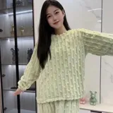 Pijama de dos piezas de tejido plush texturado con diseño de puntos en relieve, compuesto por un buzo de manga larga con cuello redondo y un pantalón largo de corte recto.