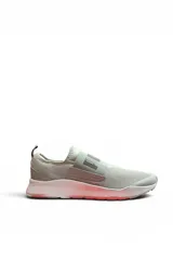 Championes deportivos Puma modelo Wired Slip On de color gris claro, con diseño sin cordones, banda elástica cruzada con el logo de la marca en relieve y suela blanca con detalles en tono rosado.