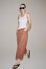 Jeans Zara Woman Collection de tiro alto y corte tapered, con diseño de rayas verticales a contraste en color marrón y beige. Presenta cinco bolsillos, trabillas para cinto y cierre frontal con cremallera y botón.