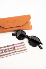 Lentes de sol polarizados con armazón redondo de acetato en color marrón translúcido y micas en tono ámbar.