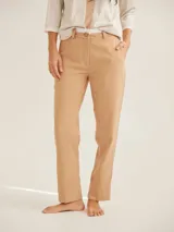 Pantalón de corte cigarette con cintura de tiro medio, cierre frontal con botón y bolsillos laterales. Presenta un diseño clásico de líneas limpias y dobladillo con costura visible.