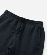 Pantalón deportivo de corte jogger, color negro, con cintura elástica ajustable mediante cordón, bolsillos laterales y puños acanalados en los tobillos. Confeccionado en tejido de algodón con interior felpudo.