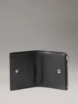 Billetera de piel color negro de Calvin Klein, con ranuras para tarjetas, compartimento para billetes, monedero con cierre y remache metálico con monograma en la parte delantera.