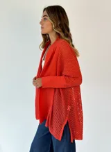 Saco tejido de punto abierto color fucsia, de manga larga y corte amplio, con cuello solapa.