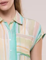 Camisa de gasa estampada con rayas verticales en tonos verde, amarillo y salmón, de manga corta estilo japonesa, cuello con solapa y cierre frontal con botones. Cuenta con un bolsillo aplicado en el frente y detalle de nudo en el ruedo.