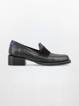 Mocasín negro de cuero con detalle de gamuza en la capellada, punta cuadrada y taco bajo.