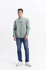 Buzo negro de algodón con cuello redondo, puños y cintura elásticos. Presenta un pequeño estampado frontal con texto en azul claro.