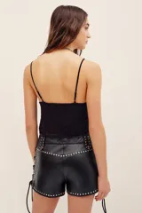 Top negro de encaje con tirantes finos, escote en V y detalles brillantes.
