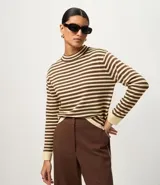 Sweater de punto de manga larga, con rayas horizontales en azul marino y blanco. Presenta cuello redondo ligeramente elevado y puños y ruedo en color blanco liso.