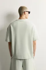 Sudadera de manga corta color crudo, corte relaxed fit, confeccionada en tejido interlock de algodón con cuello redondo.