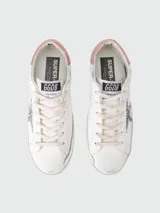 Championes Golden Goose modelo Super Star, color blanco con estrella plateada con glitter y detalles en rosa.