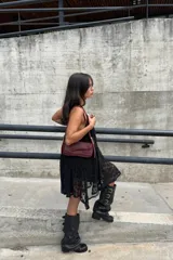 Botas de caña alta confeccionadas en cuero negro, con diseño holgado y tres correas horizontales con hebillas metálicas doradas en la parte superior. Presentan punta redondeada y taco bajo cuadrado.