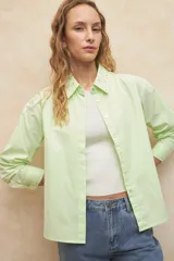 Camisa blanca de algodón con cuello clásico y mangas largas. Detalle de tachas plateadas en el cuello.