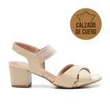 Sandalias de cuero color beige con taco cuadrado y tiras cruzadas en el empeine. Cierre con hebilla en el tobillo y detalle de elástico en la tira delantera. Marca Usaflex, modelo Tessa.