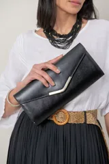 Cartera tipo sobre color negro con textura saffiano, solapa geométrica con detalle metálico en tono oro viejo.