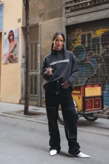 Buzo gris con cuello polo abotonado, mangas largas y estampa con la palabra "CONTAINER" en el pecho.