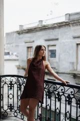 Vestido corto de punto con acabado brillante, escote halter con cuello drapeado y diseño sin mangas.