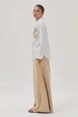 Camisa blanca de algodón y lino con bordado de flor en el frente.