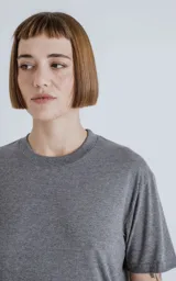 Remera de manga corta y cuello redondo, color gris melange, con calce regular y recorte en la espalda.