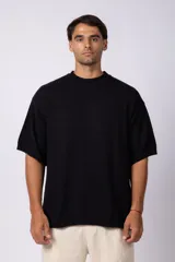 Remera de punto color crema, de manga corta, con cuello redondo acanalado y corte oversize.