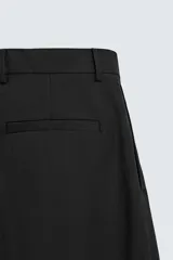 Pantalón de vestir regular fit color negro, confeccionado en tejido con mezcla de lana y elasticidad. Cuenta con cintura elástica, bolsillos frontales, bolsillos traseros de vivo con botón, y cierre frontal con cremallera y botón.