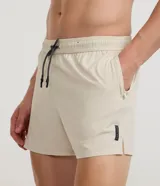 Bermuda deportiva de running para hombre en microfibra color beige, con cintura elástica, cordón ajustable y bolsillos laterales.