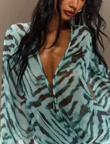 Vestido corto estampado con efecto animal print en tonos aqua y marrón, escote profundo en V cruzado y mangas largas anchas y acampanadas.