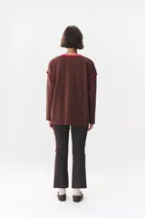 Remera de manga larga con corte oversized, color azul marino con cuello redondo en contraste color marrón. Presenta costuras decorativas a contratono hechas a mano en la zona de los hombros y logo bordado en el centro del pecho.