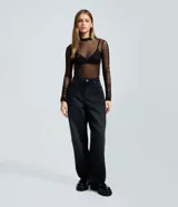 Pantalón de jean color negro con corte baggy y cintura media. Presenta estrellas bordadas con acabado desflecado en las piernas y bolsillos funcionales.