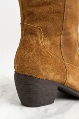 Bota de caña alta color marrón, de gamuza, con taco cuadrado y punta fina.