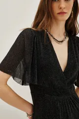 Vestido midi de color negro con acabado brillante, escote en V cruzado, mangas cortas con volados y falda con niveles fruncidos.