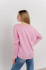 Remera manga larga color rosa con bolsillo en el pecho y corte irregular en el ruedo.