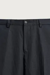Pantalón de traje regular fit de lino color verde militar, con bolsillos laterales y bolsillos traseros de doble vivo con botón. Cierre frontal con cremallera y botón.
