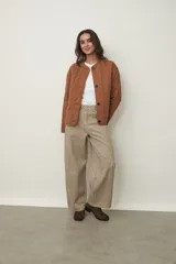 Campera acolchada color marrón claro, con cuello redondo, cierre frontal de botones y diseño de rombos.