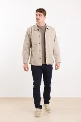 Sobrecamisa color gris oscuro, de corte recto, con cuello camisero, cierre frontal con botones, mangas largas con puños abotonados y dos bolsillos de parche en el pecho.