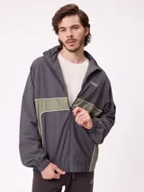 Rompevientos Rusty con cierre frontal, capucha y diseño de bloques de color en gris y verde militar. Cuenta con puños elásticos y logo de la marca en el pecho.