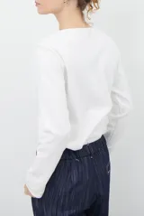 Remera de manga larga con cuello redondo, confeccionada en tejido de punto gris melange con costuras visibles en contraste.