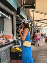 Bandolera pequeña de diseño rectangular en color beige, confeccionada en cuero sintético. Presenta una correa larga ajustable del mismo material y cierre superior con cremallera. Incluye el logo de la marca grabado en la parte frontal.